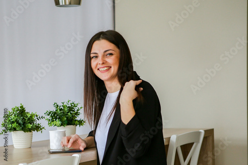 Happy young european saleswoman looking at the camera while greeting a customer. Smiling female executive manager, secretary offering professional business services with digital tablet standing in the