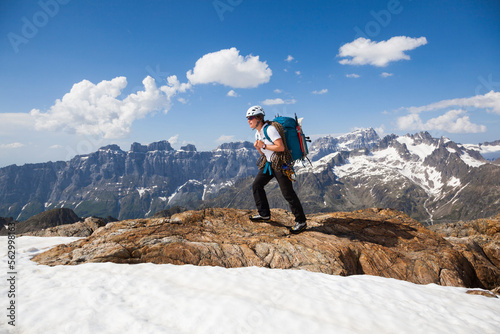 A woman hikes near the summit of Tierbergli, Bern, Switzerland with climbing equipment. photo