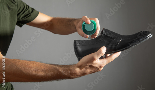 Man using antibacterial spray against unpleasant odors.
