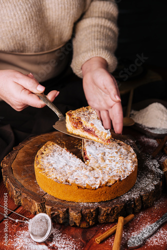 Woman holding grated pie with lemon curd and jam inside