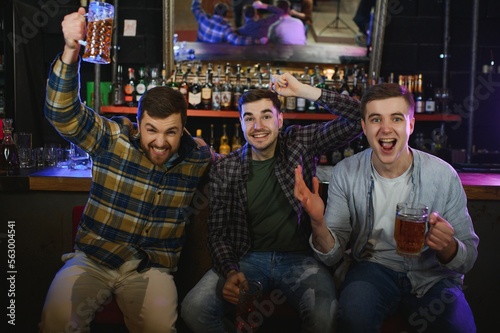 Group of excited friends in beer pub watching sports match