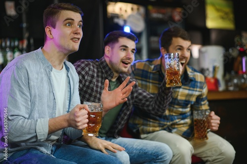 Sport  people  leisure  friendship  entertainment concept - happy male football fans or good yuong friends drinking beer  celebrating victory at bar or pub. Human positive emotions concept