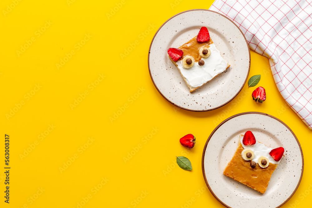 Obraz premium Kids breakfast with fox faces sandwiches made from peanut butter and strawberries