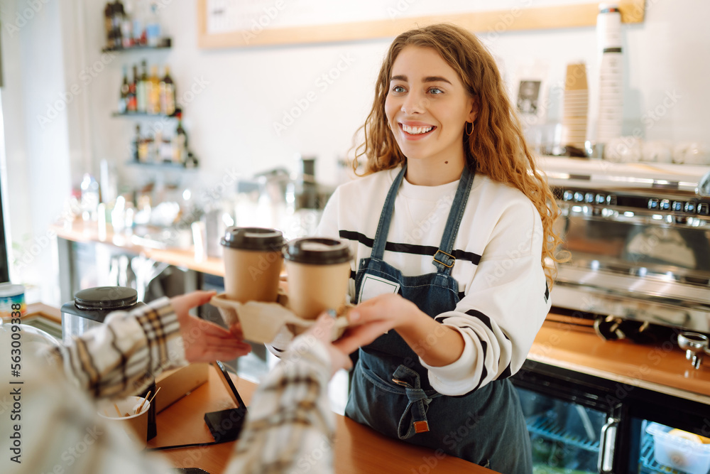 Barista girl holding take away coffee at the cafe shop. Takeaway food. Barista girl holding take away coffee at the cafe shop. Takeaway food.