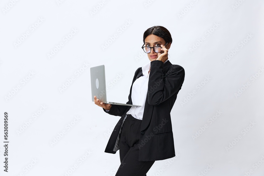 Business woman with laptop in hand in black business suit shows signals gestures and emotions on white background, freelancer job online training Business woman with laptop in hand in black business suit shows signals gestures and emotions on white background, freelancer job online training