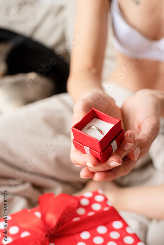 Closeup of female hands holding red giftbox with ring
