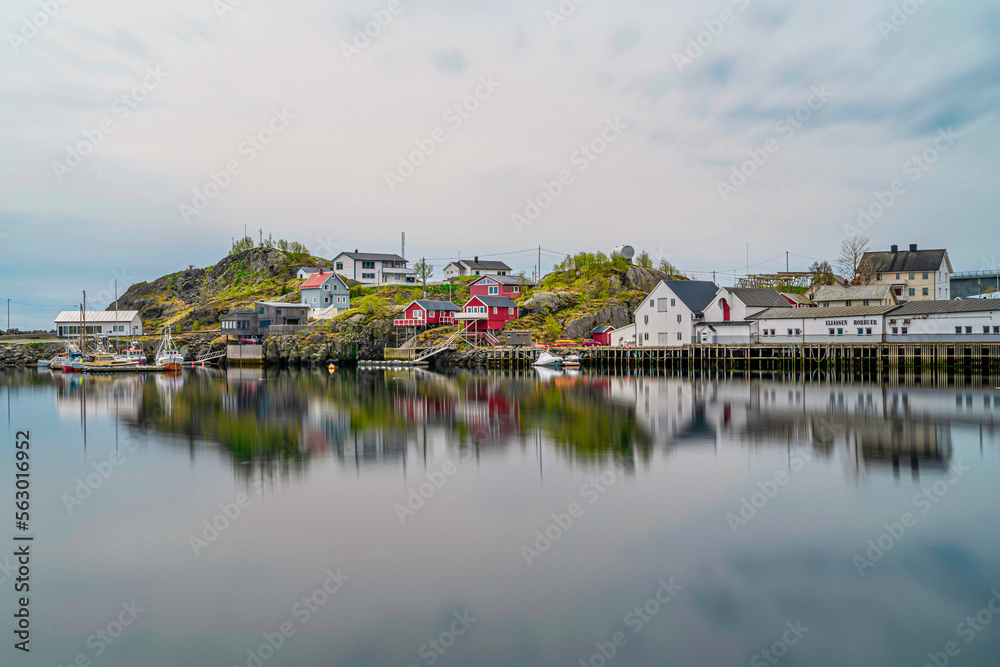 Typical Norwegian colored houses at Reine village in Lofoten, Norway, during spring on a clear day with clouds