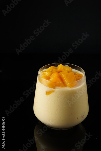 Healthy mango smoothie on the black background