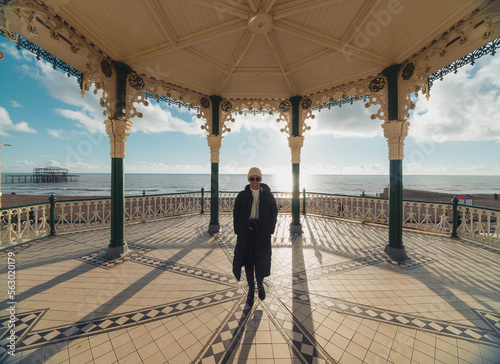 Brighton and Hove England, The Bandstand, opened 1884, Designed by Phillip Lockwood, with blue sky and clouds with an adult female person silhouette photo