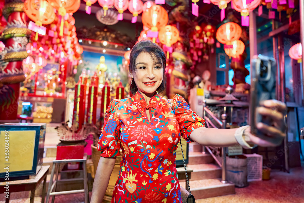 thai woman taking selfie at temple in yaowarat china town bangkok during chinese new year wearing cheongsam