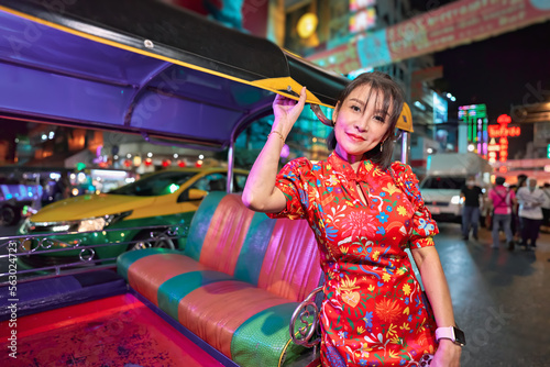 thai woman in tuk tuk wearing cheongsam at yaowarat chinatown bangkok during chinese new year