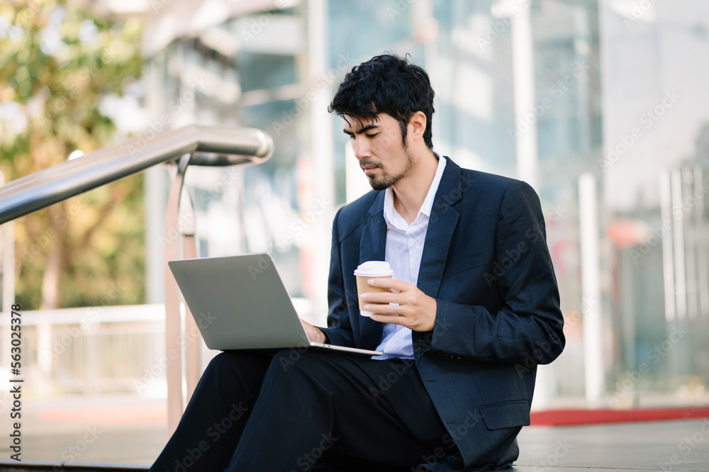 Positive Asian Entrepreneur Talking On Cellphone Using Digital Tablet During Coffee Break In City Urban Area. Positive Asian Entrepreneur Talking On Cellphone Using Digital Tablet During Coffee Break In City Urban Area.