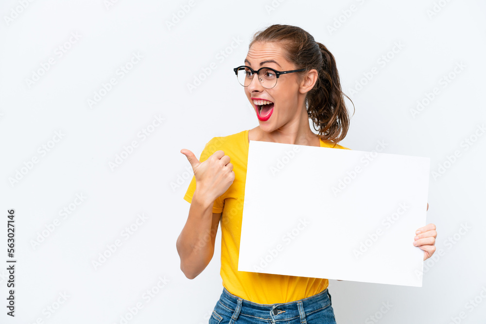 Young caucasian woman isolated on white background holding an empty placard and pointing side Young caucasian woman isolated on white background holding an empty placard and pointing side