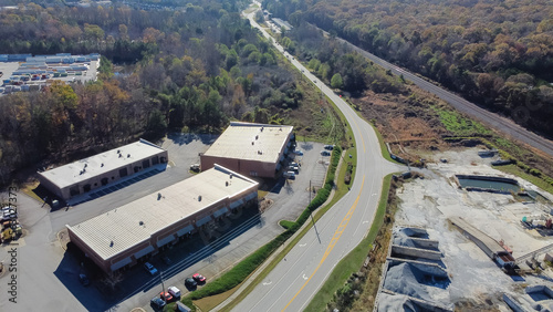 Aerial view strips mall in industrial zone with ready-mixed concrete batching plant, warehouse and highway in Georgia, USA