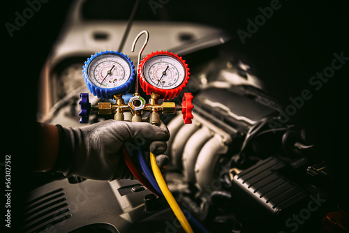 Car care maintenance and servicing, Hand technician auto mechanic using measuring manifold gauge check refrigerant and filling car air conditioner to fix repairing heat conditioning system.
