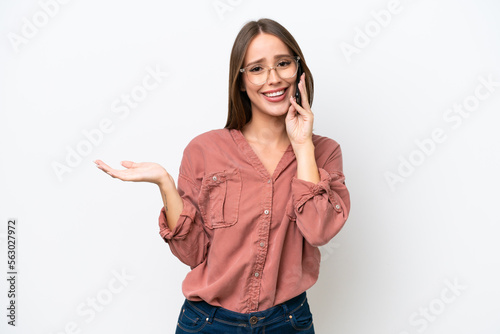 Young pretty caucasian woman isolated on white background keeping a conversation with the mobile phone with someone