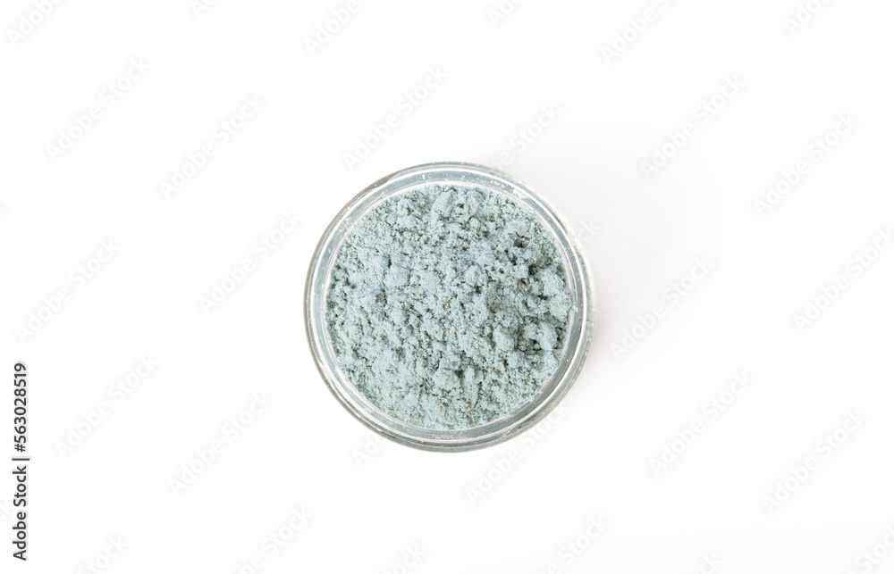Blue spirulina powder in glass jar isolated on white background. Natural vegan superfood. Food supplement. Phycocyanin extract.