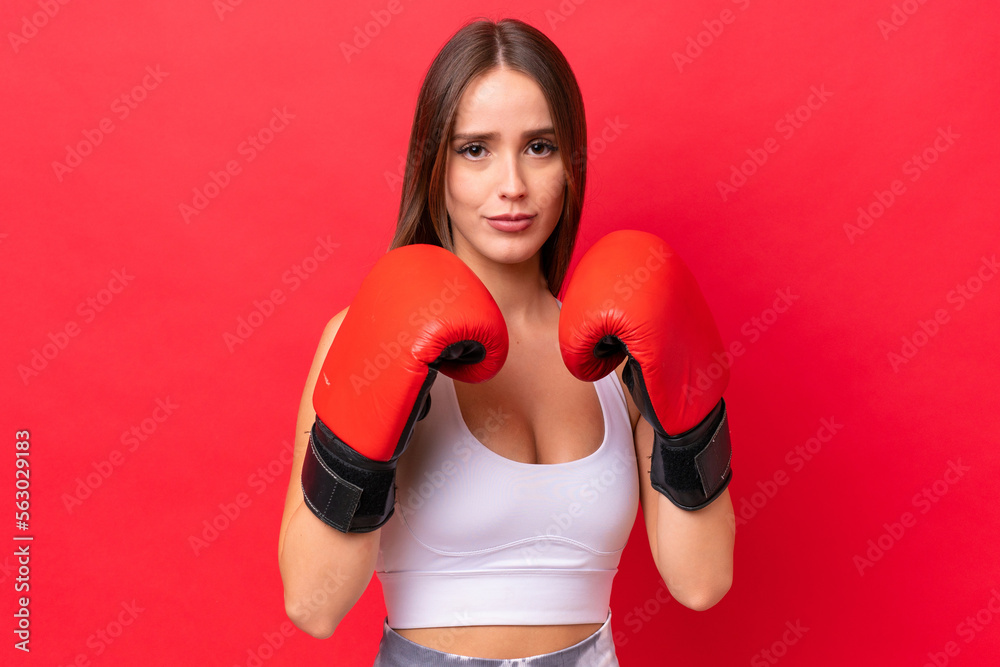 Young beautiful caucasian woman isolated on red background with boxing gloves Young beautiful caucasian woman isolated on red background with boxing gloves