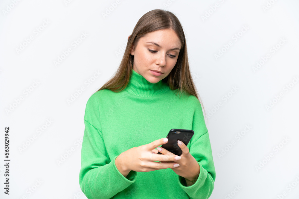 Young beautiful blonde woman isolated on white background sending a message with the mobile Young beautiful blonde woman isolated on white background sending a message with the mobile
