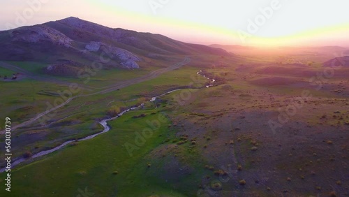 The drone flies by the river over the river at sunset, a heavenly place, a river valley, a fabulous place, a magical landscape.The river is parallel to the road. photo