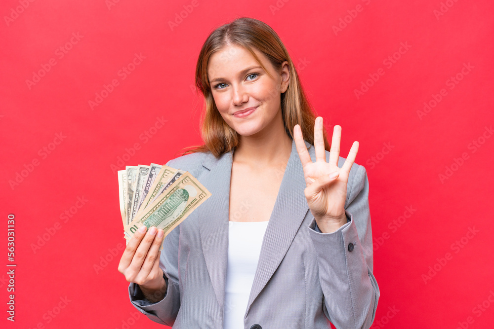 Young business caucasian woman holding money isolated on red background happy and counting four with fingers Young business caucasian woman holding money isolated on red background happy and counting four with fingers