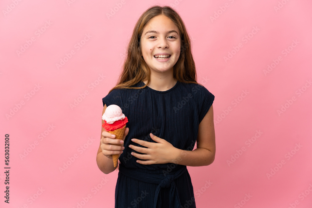 Child with a cornet ice cream over isolated pink background smiling a lot Child with a cornet ice cream over isolated pink background smiling a lot