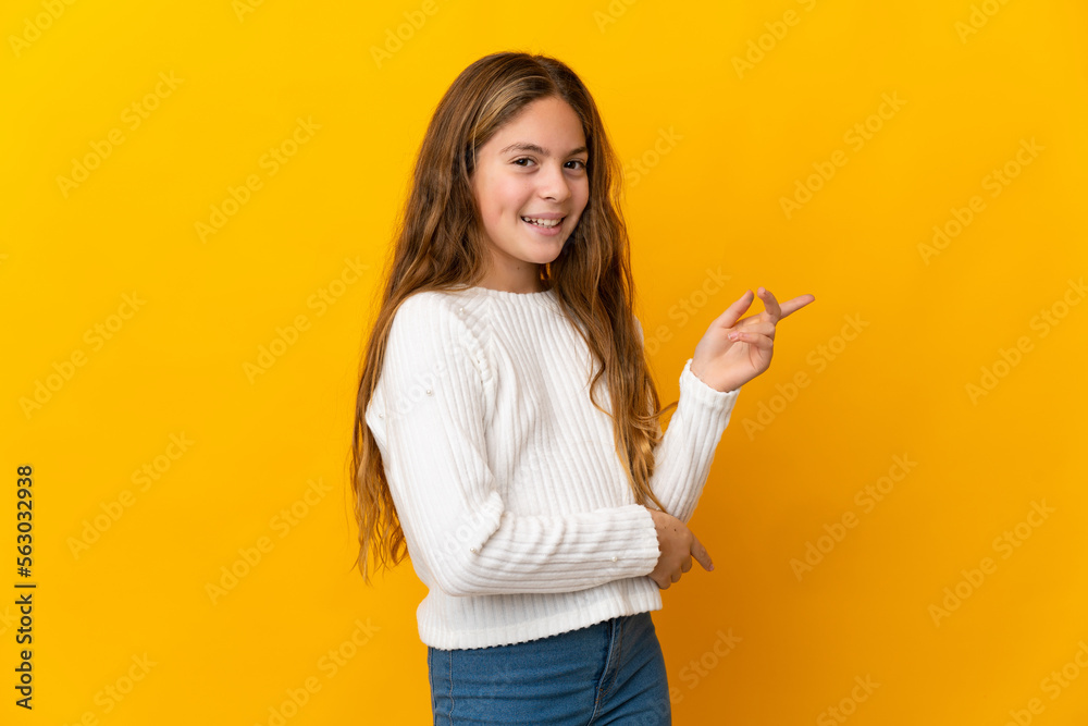 Child over isolated yellow background pointing finger to the side Child over isolated yellow background pointing finger to the side