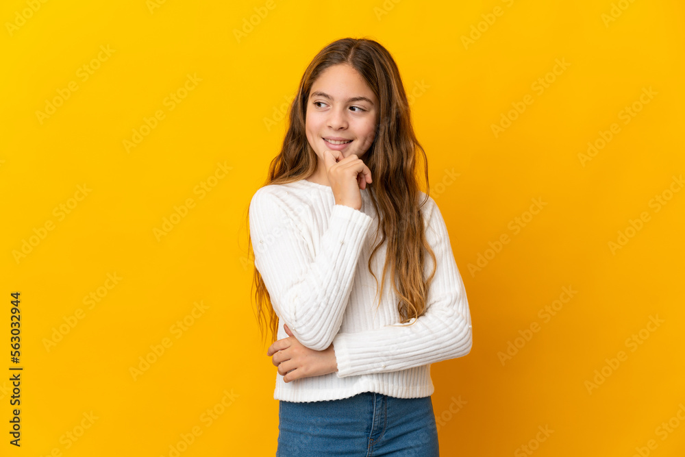 Child over isolated yellow background and looking up Child over isolated yellow background and looking up