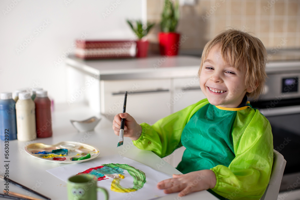 Cute blond boy, preschool child, painting at home with aquarelle colors Cute blond boy, preschool child, painting at home with aquarelle colors