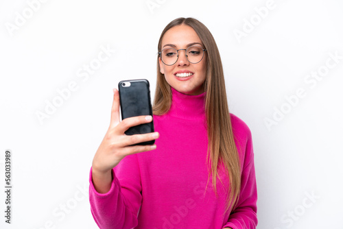 Young caucasian woman isolated on white background making a selfie
