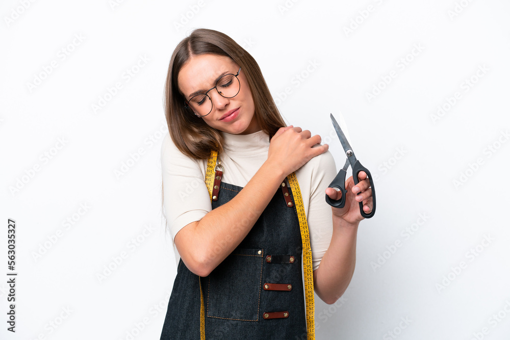 Young seamstress woman isolated on white background suffering from pain in shoulder for having made an effort Young seamstress woman isolated on white background suffering from pain in shoulder for having made an effort