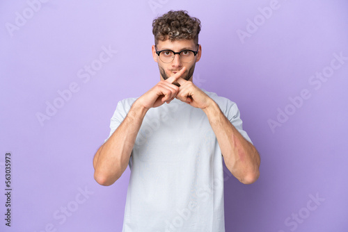 Delivery caucasian man isolated on purple background showing a sign of silence gesture