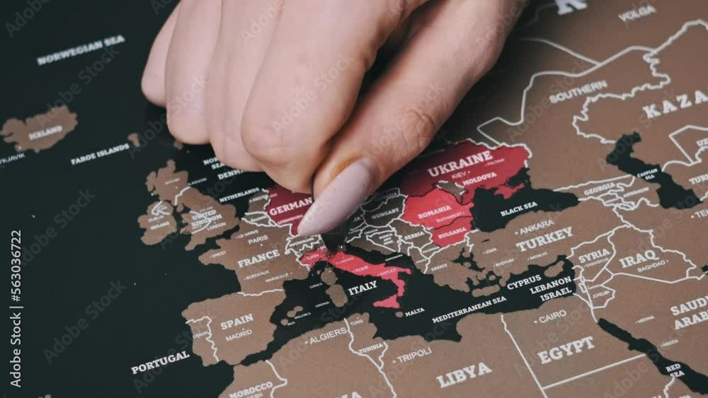 Female Hand Scratching country of Italy on the Surface of Scratch World