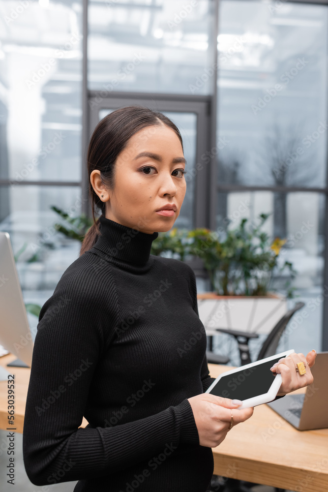 Young asian designer holding digital tablet and looking at camera in studio. Young asian designer holding digital tablet and looking at camera in studio.