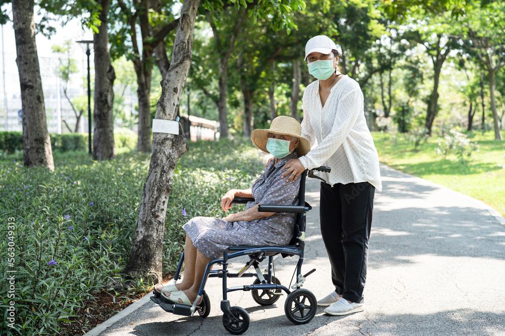 Caregiver help and care Asian senior or elderly old lady woman patient sitting on wheelchair and wear a face mask to travel in park, Caregiver help and care Asian senior or elderly old lady woman patient sitting on wheelchair and wear a face mask to travel in park,