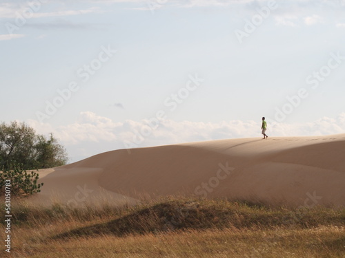 person walking in the sand dunes