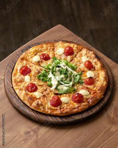 Traditional Italian pizza Margarita with mozzarella and tomatoes. Mediterranean food. Vegetarian dish. Wooden table, dark background. Copy space. Top view.