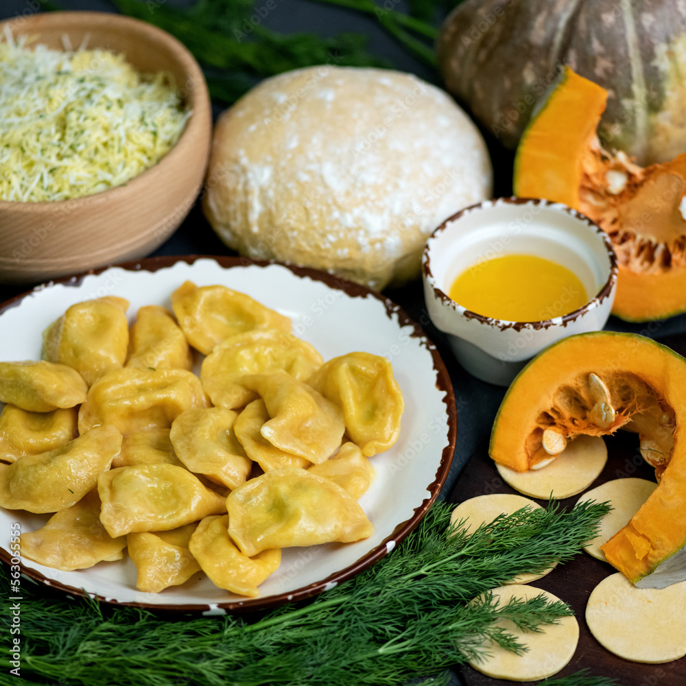 Vareniki from pumpkin doughwith cheese and herbs from pumpkin dough. Boiled dumplings on a plate in composition with stuffing, dough. Vareniki with cheese and herbs from pumpkin dough. Boiled vareniki