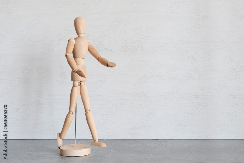 Wooden mannequin, male demonstrates with his hands. Copyspace.