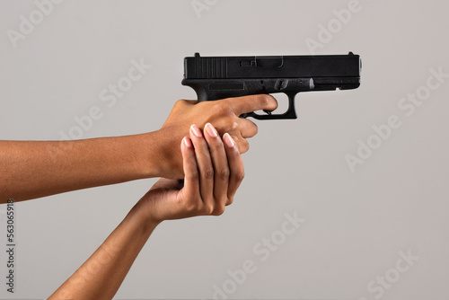 Female black hands with gun