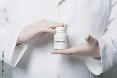 Cropped view of doctor in white coat and gloves holding jar with omicron xbb lettering isolated on grey.