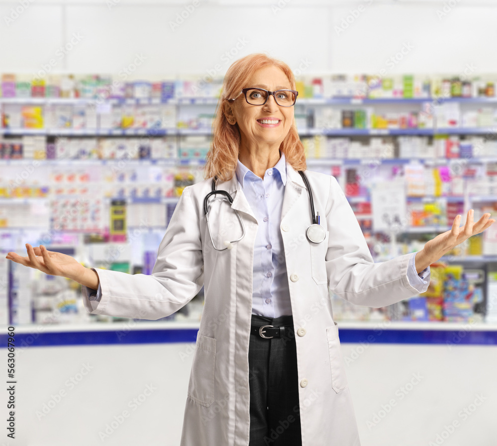 Female chemist smiling and gesturing with hands in a pharmacy Female chemist smiling and gesturing with hands in a pharmacy