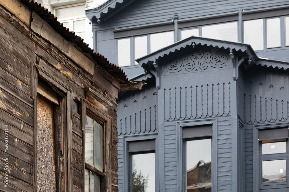 Abandoned house corner on the backdrop of the renovated building. 