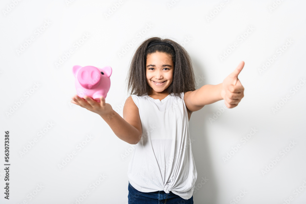 Adorable 9 years child girl on studio white background holding piggy bank Adorable 9 years child girl on studio white background holding piggy bank