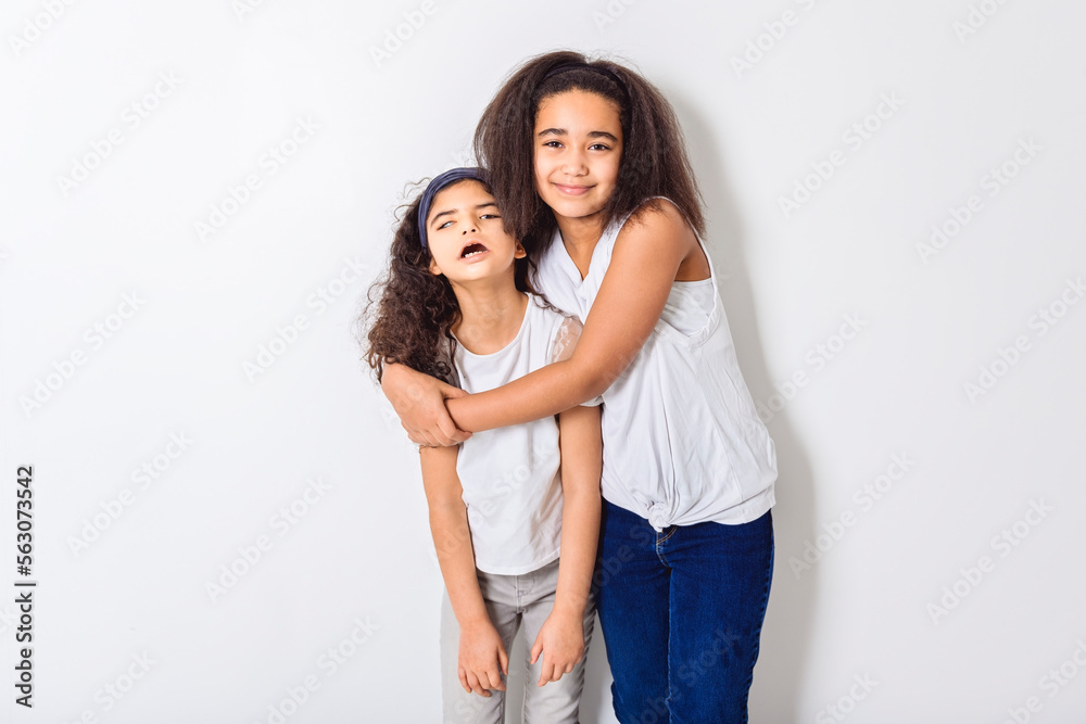 Adorable 9 years child girl on studio white background with her sister Adorable 9 years child girl on studio white background with her sister