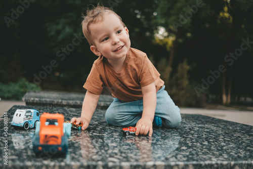 Little boy playing with toy car outside