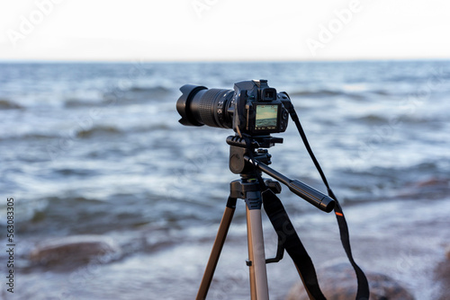 camera on a tripod mounted on the seashore in the process of shooting