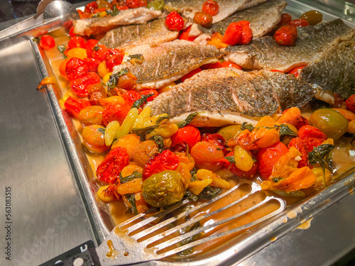 Stewed fish with tomatoes in a large iron bowl. at catering event on some festive event, party or wedding reception. buffet. photo