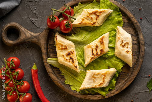 Delicious fried pita bread roll with cottage cheese and herbs photo