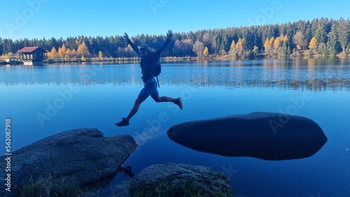 happy girl jumping on rocks, Fichtel lake, Germanz photo
